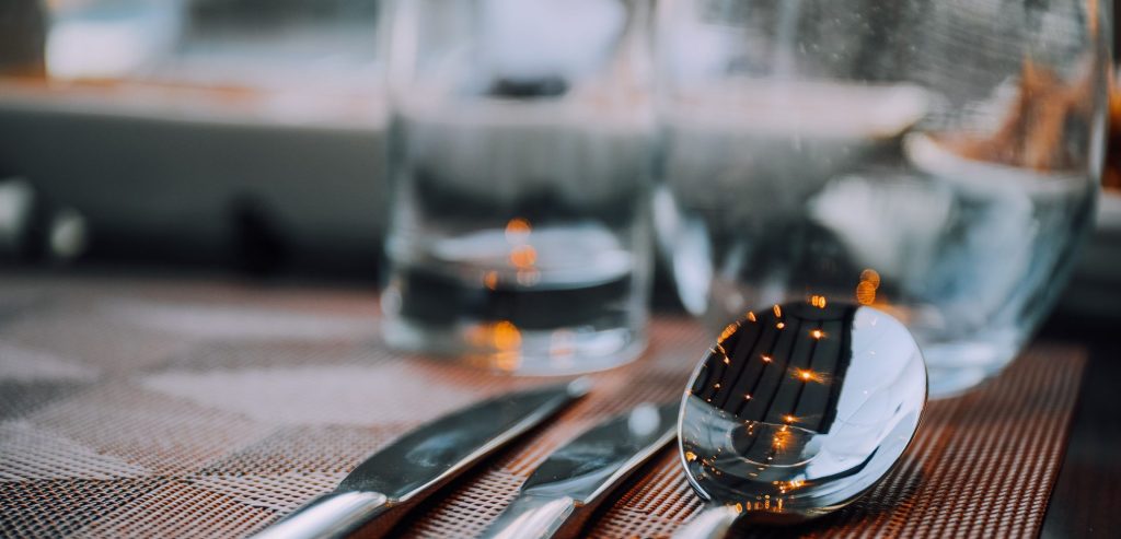 A candlelit table setting at SEVEN, with glassware and polished cutlery