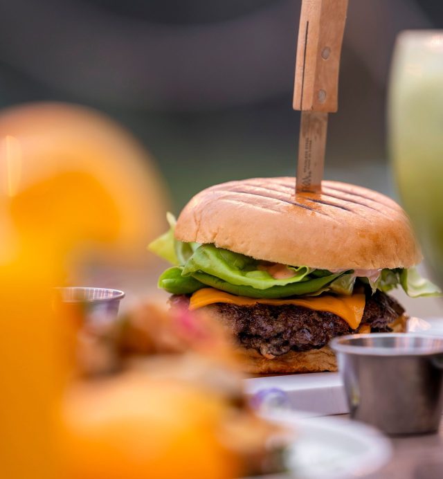 A burger served with a skewer at lunch